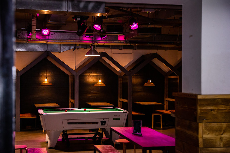 The pool table illuminated by pink lights