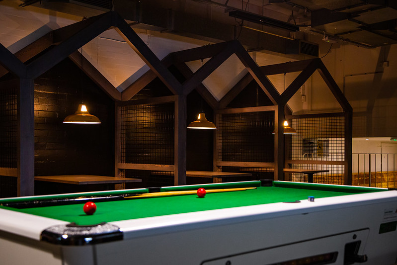 A pool table in front of some seating