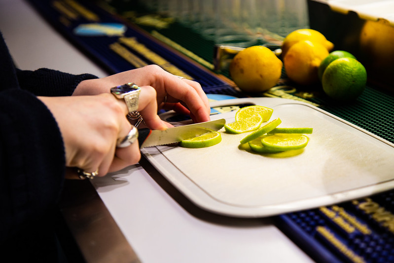 A staff member chopping lime widges for drinks