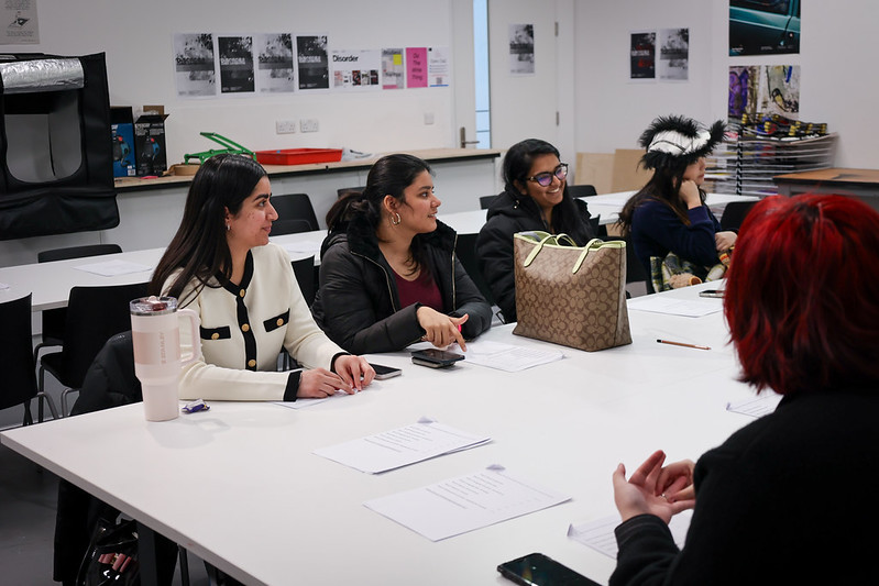 A group of students in a classroom listening to lecturers at the front of the room.